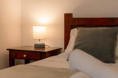 a bedroom with a bed and a table with a lamp at Habitación doble delux - Casa Esmeralda in San José