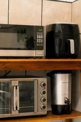 a microwave and a toaster oven on a shelf at Habitación doble delux - Casa Esmeralda in San José