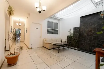 a living room with a couch and a stone wall at Habitación doble delux - Casa Esmeralda in San José
