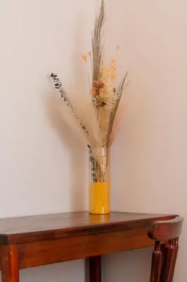 a vase filled with flowers on a wooden table at Habitación doble pequeña - Casa Esmeralda in San José