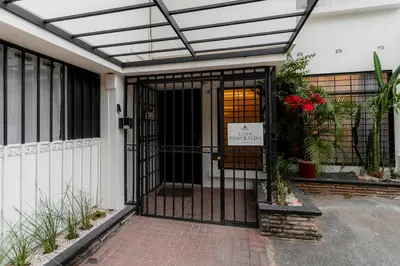 an entrance to a house with an iron gate at Habitación doble pequeña - Casa Esmeralda in San José