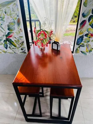 a wooden table with a vase of flowers on it at Cabina de las Hojas Monteverde in Monteverde Costa Rica