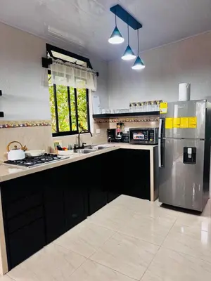 a large kitchen with a stainless steel refrigerator at Cabina de las Hojas Monteverde in Monteverde Costa Rica