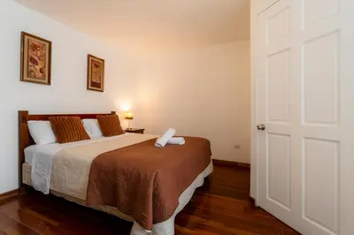a bedroom with a bed and a white door at Habitacion triple clasica - Casa Esmeralda in San José