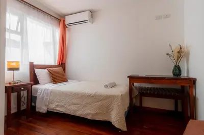 a small bedroom with a bed and a window at Habitacion triple clasica - Casa Esmeralda in San José