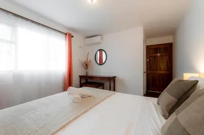 a bedroom with a large white bed with a window at Habitacion doble delux - Casa Esmeralda in San José