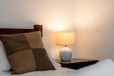 a lamp on a night stand next to a bed at Habitacion doble delux - Casa Esmeralda in San José