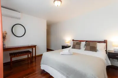 a bedroom with a large bed and a mirror at Habitacion doble delux - Casa Esmeralda in San José