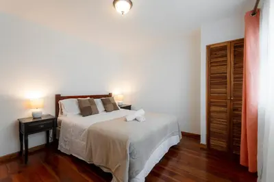 a bedroom with a bed and two night stands with lamps at Habitacion doble delux - Casa Esmeralda in San José