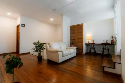 a living room with a white couch and a table at Habitacion doble delux - Casa Esmeralda in San José