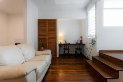 a living room with a white couch and a table at Habitacion doble delux - Casa Esmeralda in San José