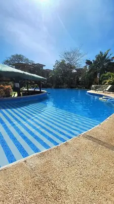 a large swimming pool with blue water at Relajante apartamento cerca de tamarindo in Garita
