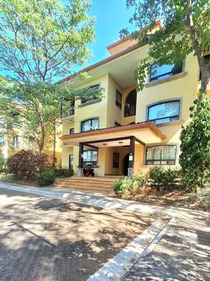 a large yellow building with a porch and a driveway at Relajante apartamento cerca de tamarindo in Garita
