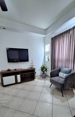 a living room with a chair and a flat screen tv at Relajante apartamento cerca de tamarindo in Garita