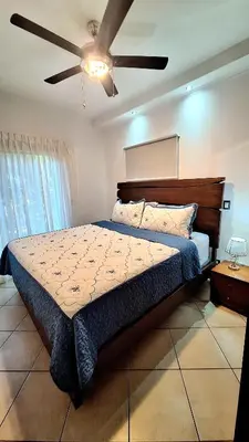 a bedroom with a bed and a ceiling fan at Relajante apartamento cerca de tamarindo in Garita