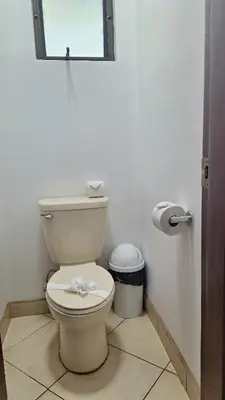 a bathroom with a toilet and a trash can at Relajante apartamento cerca de tamarindo in Garita
