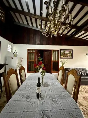 a dining room with a table with a bottle of wine at Doucemaison in Tilarán