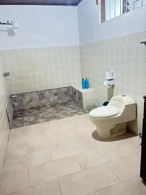 a bathroom with a toilet and a shower stall at Doucemaison in Tilarán