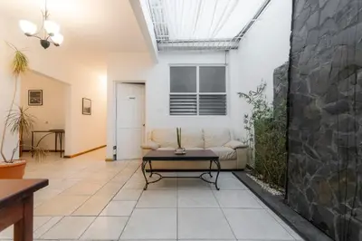 a living room with a couch and a table at Habitacion familiar - Casa Esmeralda in San José