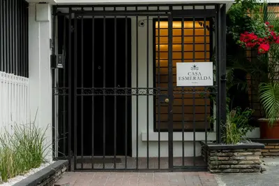 an entrance to a building with a gate with a sign on it at Habitacion familiar - Casa Esmeralda in San José
