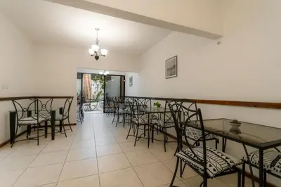 a dining room with tables and chairs in a room at Habitacion familiar - Casa Esmeralda in San José