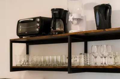 a shelf with glasses and a toaster on it at Habitacion familiar - Casa Esmeralda in San José
