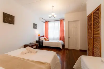 a bedroom with two beds and a window at Habitacion familiar - Casa Esmeralda in San José