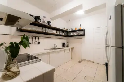 a white kitchen with a sink and a refrigerator at Habitacion familiar - Casa Esmeralda in San José