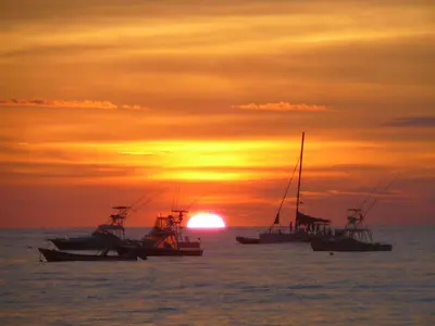 a group of boats in the ocean at sunset at Casas Buenas Brisas in Ojochal