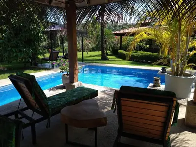 a patio with chairs and a swimming pool at Casas Buenas Brisas in Ojochal