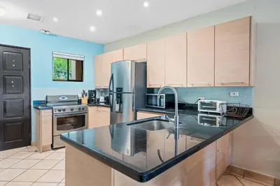a kitchen with a sink and a refrigerator at Ocean View Condo with Resort Style Pool in Tamarindo