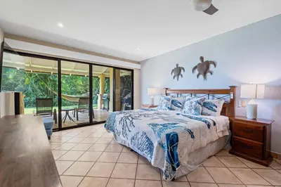 a bedroom with a bed and a sliding glass door at Ocean View Condo with Resort Style Pool in Tamarindo