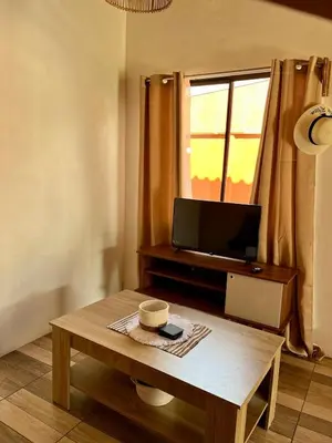a living room with a coffee table and a television at Cabaña Hojancha in Hojancha