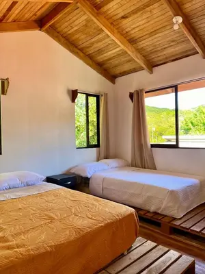 a bedroom with two beds and a window at Cabaña Hojancha in Hojancha
