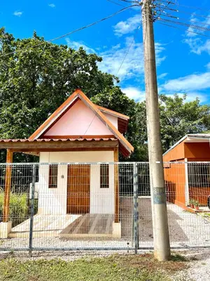 a small house behind a fence with a pole at Cabaña Hojancha in Hojancha