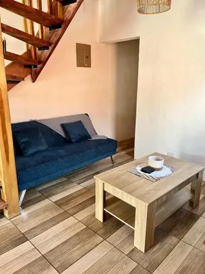 a living room with a blue couch and a coffee table at Cabaña Hojancha in Hojancha