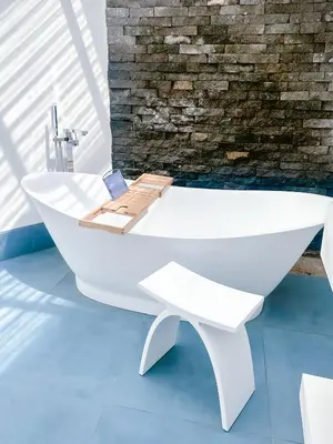 a white bath tub in a bathroom with a brick wall at T Loft in Playa Hermosa