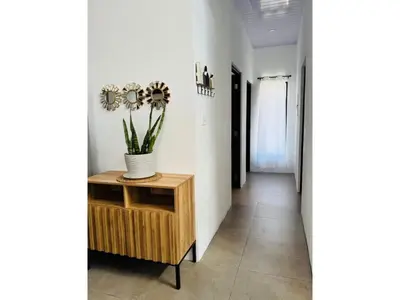 a hallway with a table and a vase with flowers on it at Finca Dontricia Official in Cañas Dulces