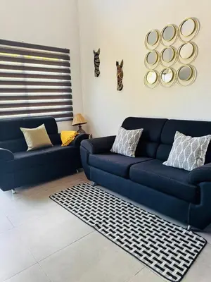 a living room with two blue couches and a rug at Finca Dontricia Official in Cañas Dulces