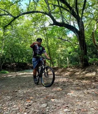 a man riding a bike on a forest trail at Finca Dontricia Official in Cañas Dulces
