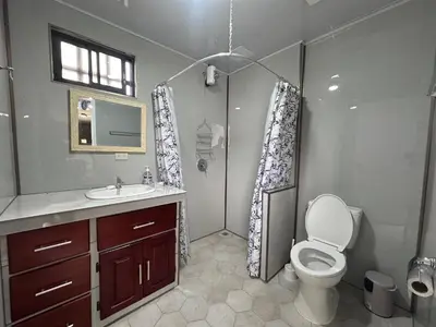 a bathroom with a shower and a toilet and a sink at ZuGranjita Alojamiento1 in Alajuela City