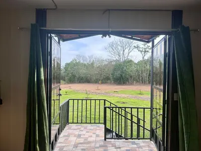an open door to a balcony with a view of a field at ZuGranjita Alojamiento1 in Alajuela City
