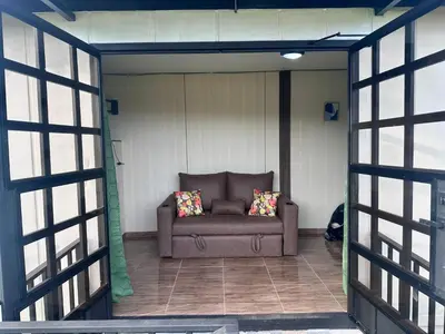 a couch sitting in the middle of a screened in porch at ZuGranjita Alojamiento1 in Alajuela City