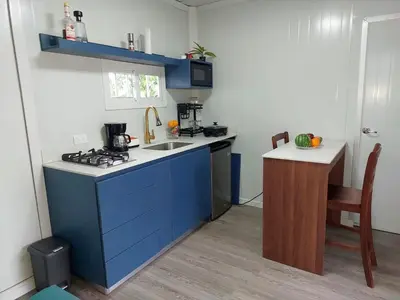 a small kitchen with a blue island with a sink at Cabaña Tesoro Escondido in Guápiles