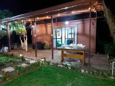 a house with a table in the backyard at night at Cabaña Tesoro Escondido in Guápiles