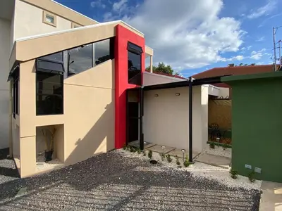 a red and white house with a garage at Casa Iriria, in harmony with nature in Carpintero