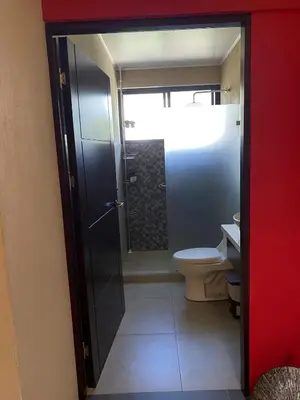 a bathroom with a toilet and a glass door at Casa Iriria, in harmony with nature in Carpintero