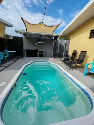 a large swimming pool in the middle of a backyard at Bandera Beach Cabins in Parrita