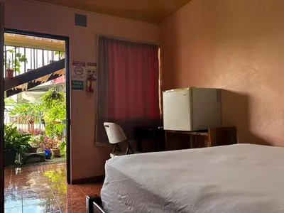 a bedroom with a white bed and a refrigerator at Hotel Mavi in El Achiote