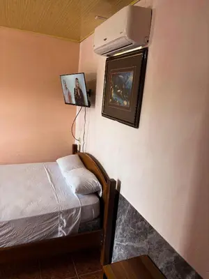 a bedroom with a bed and a air conditioner on the wall at Hotel Mavi in El Achiote